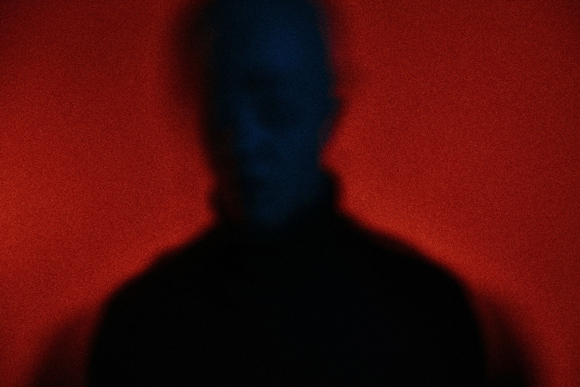 Richmond-writer-Cameron-Beyrent_photo-andrej-lisakov_RVA-Magazine-2026 Blurred silhouette of a person against a deep red background, illustrating Cameron Beyrent's personal essay about depression and finding a new beginning in Richmond.